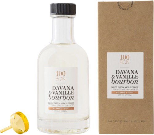 En doftflaska med en box, märkt 'Davana & Vanille Bourbon' och ett litet guldobjekt nära.