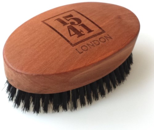 En träskoförborste med svarta borst och en logo som säger "1541 LONDON" på toppen.