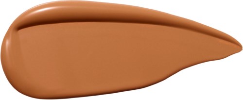 En klutt av beige vätska, tjockare i ena änden, på vit bakgrund.