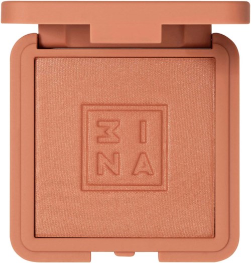 A peach-colored compact with a pressed powder blush inside and a logo embossed in the center.
