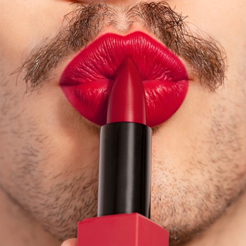 Person with a beard and mustache applies bright red lipstick, lips are puckered near lipstick.