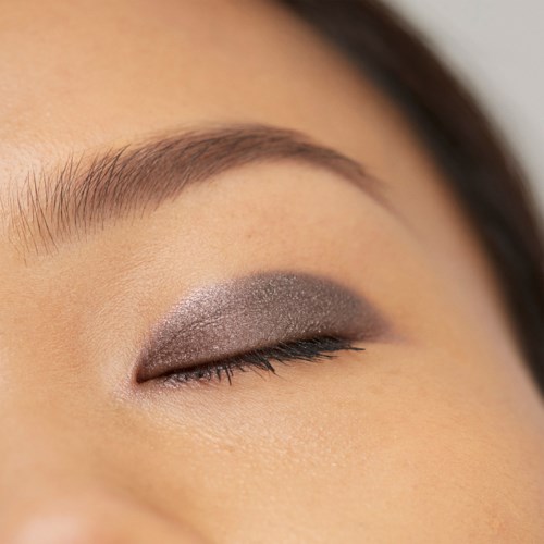 Øjne med lukkede øjenlåg, makeup, velplejet øjenbryn og glat hud.
