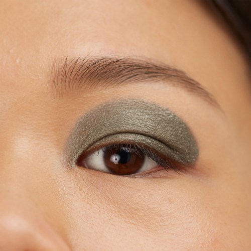 Close-up of an eye with green eyeshadow covering the eyelid.
