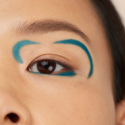 Øjet har blå makeup-linjer over og under, der fremhæver øjenlåget.