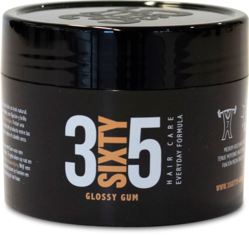 Svart rund behållare med vit, orange och grå text. Den står "36X5 Glossy Gum" för hårvård.