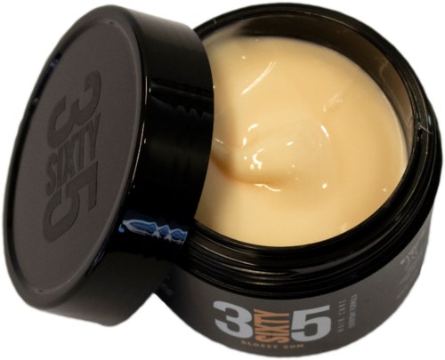 En öppen svart behållare med kräm eller lotion inuti, märkt med orden "3-5" och "STAY".