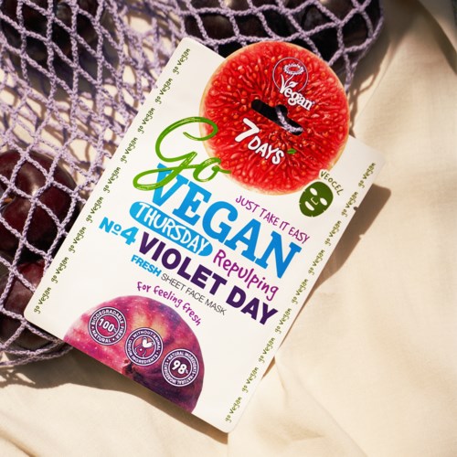 En vegansk ansiktsmaske med fruktdesign og fargerik tekst for veganerens dag.