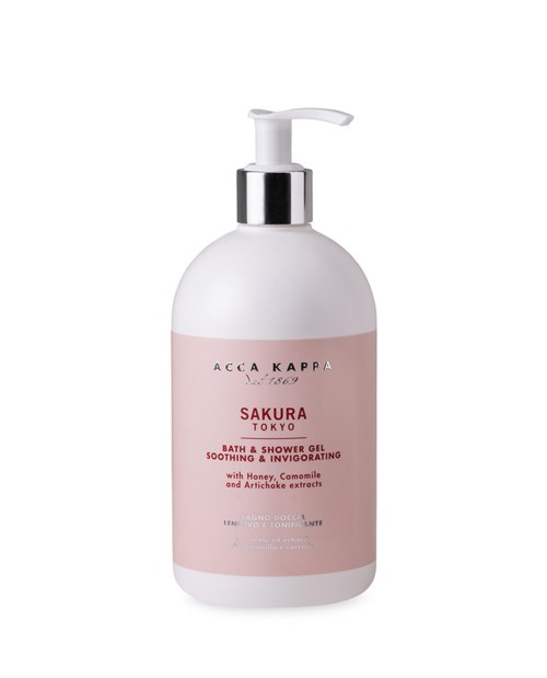 En vit flaska med pump, rosa etikett och svart text för Sakura bad- och duschgel.