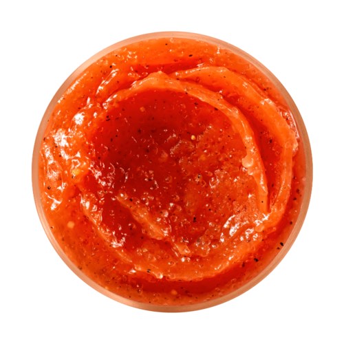 En liten skål med krydret rød saus, muligens salsa, med synlige urter og frø.