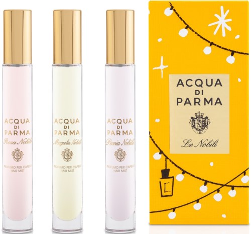Tre parfymflaskor och en gul låda med vita dekorationer och texten 'Acqua di Parma'.