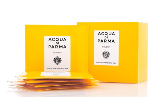 En gul box och påsar med etiketten 'Acqua di Parma Colonia', sannolikt parfym eller hudvårdsprodukter.