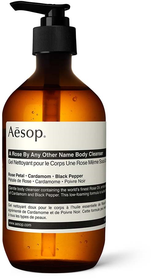 Gulbrun flaske med sort pumpe, mærket Aesop Rose Body Cleanser, indeholder rosen, kardemomme og sort peber.