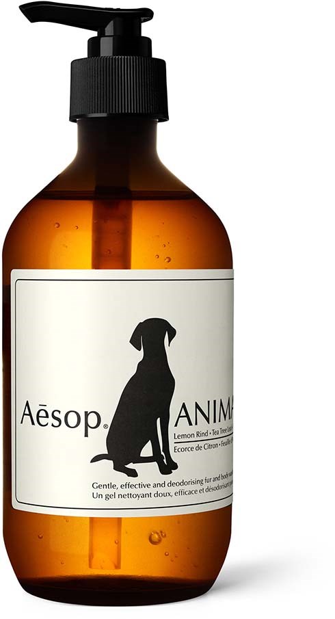 A brown bottle with a black pump contains Aesop dog-themed deodorizer liquid, with a label showing a dog silhouette.