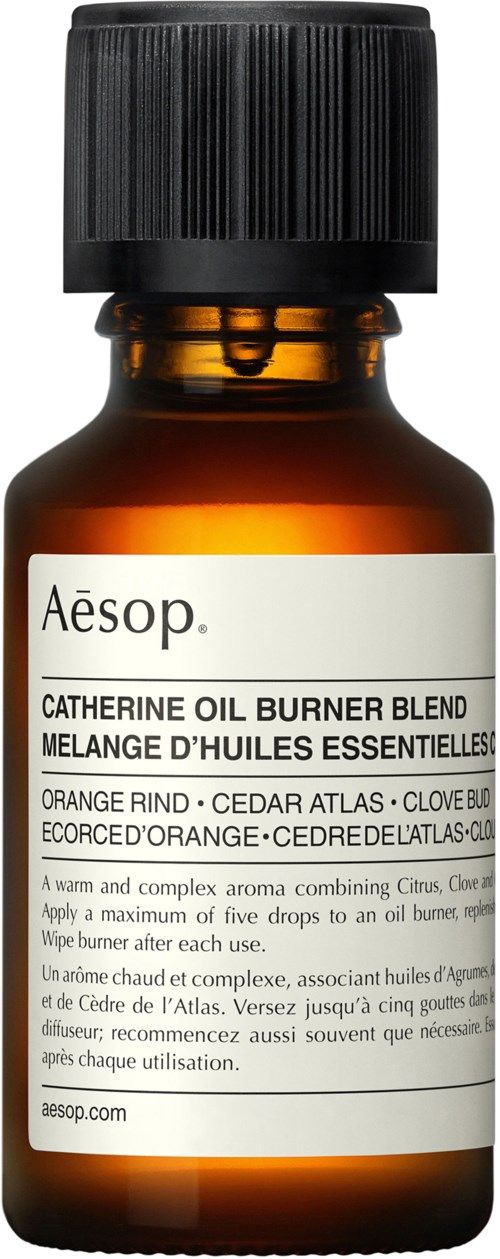 Braune Glasflasche mit schwarzem Deckel enthält Aesop's essentielle Öl-Mischung namens Catherine Oil Burner Blend, mit Zitrus- und Zedernholzduft.