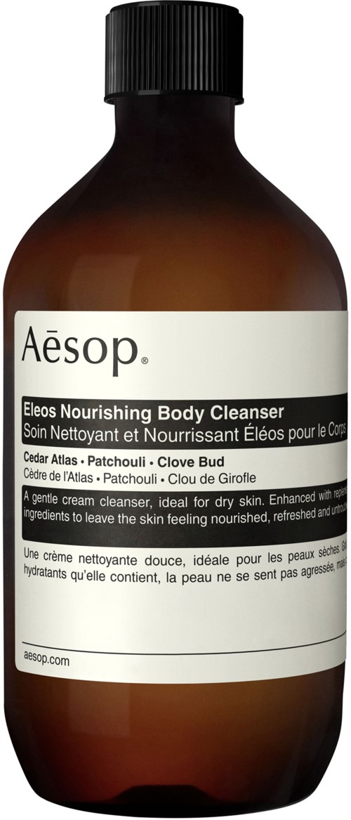 En brun flaske med Aesop Eleos nærende kropsrens med hvid etiket og sort låg.