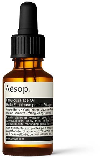 A small brown bottle with a black dropper, labeled Aesop Fabulous Face Oil, contains natural skincare product.