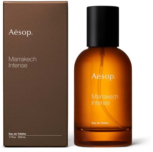 En flaske og eske med Aesop Marrakech Intense parfyme, brune og svarte farger, med enkel tekst.