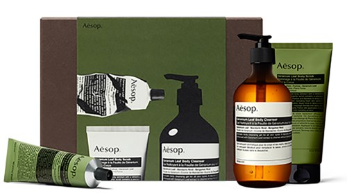 En samling Aesop hudplejeprodukter, herunder rør, flasker og en æske, i grøn, sort og ravfarvet.
