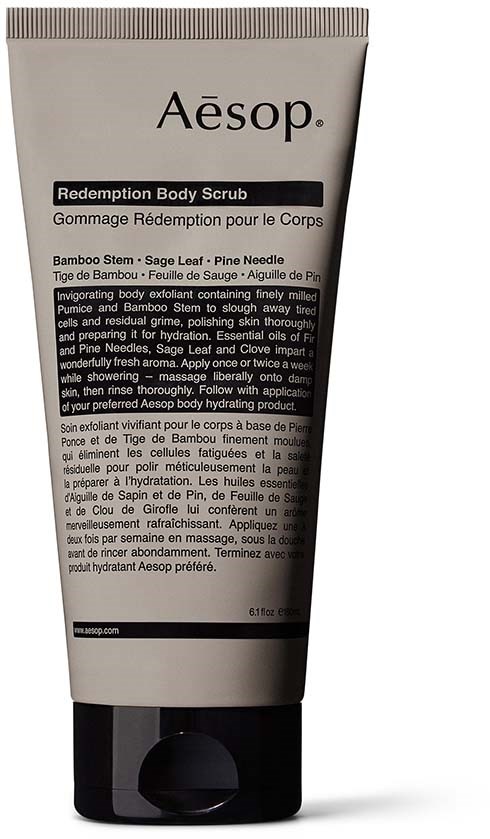 Aesop-logga och en tub med kroppsscrub med bambu, salvia och tallnålar i svart, vitt och grått.