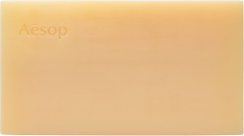 A rectangular box with a soft orange color and the brand name Aesop on it.
