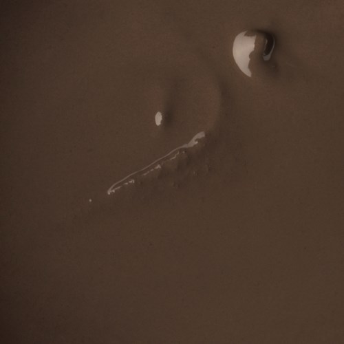 A close-up of a person's nose with water droplets and a small tear on the skin.