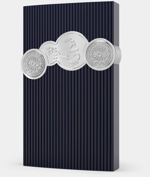 En silvermynt med intrikata mönster ligger på en mörk, texturerad yta. Mynten har några asiatiska tecken.