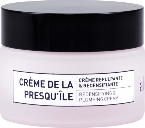 Valkoinen purkki mustalla kannella, etiketti lukee "Crème de la Presqu'île", tummanlila teksti, voide on ihonhoitoon.
