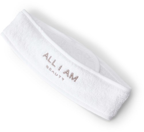 En vit pannlapp med texten "ALL I AM" och "BEAUTY" på.
