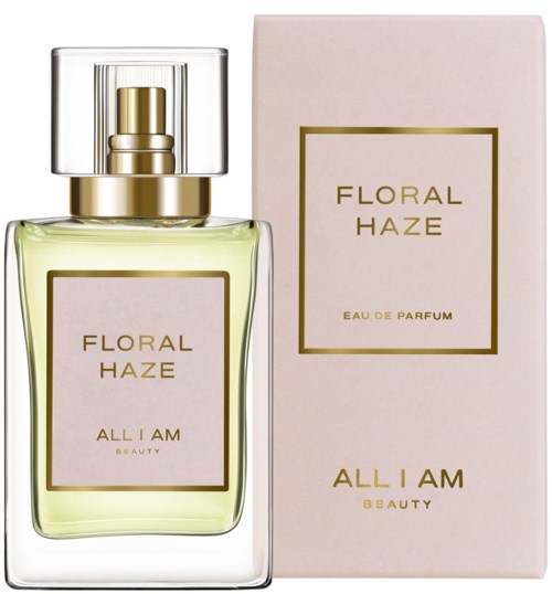 A perfume bottle with a light green liquid and a pink box with gold and brown label reading 'Floral Haze' and 'All I Am Beauty.'