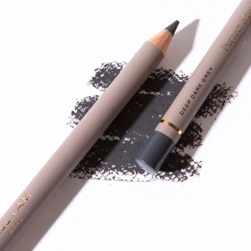 A grey makeup pencil and a lipstick laying on a white surface with black makeup smudges.