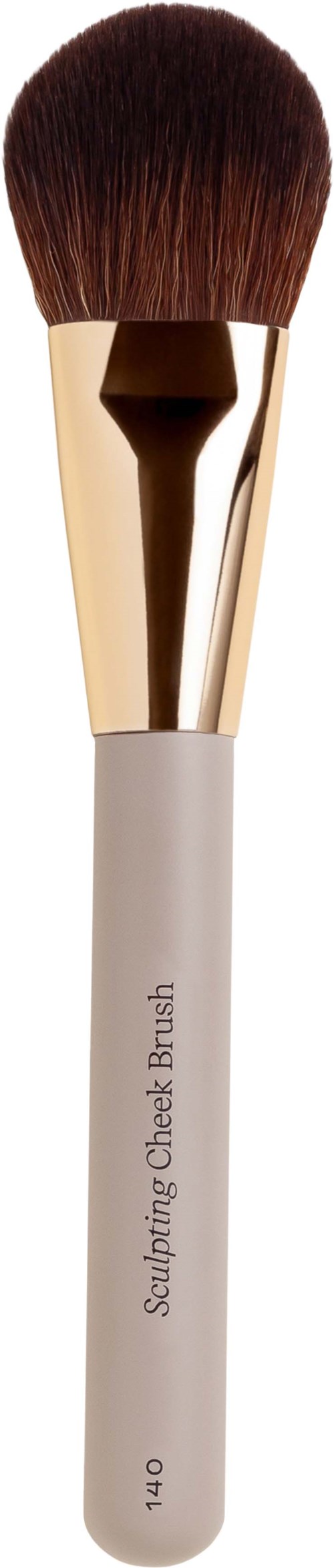 En makeupborste med vit handtag, guldfärgad metalldel och bruna hår för ansiktskonturering.