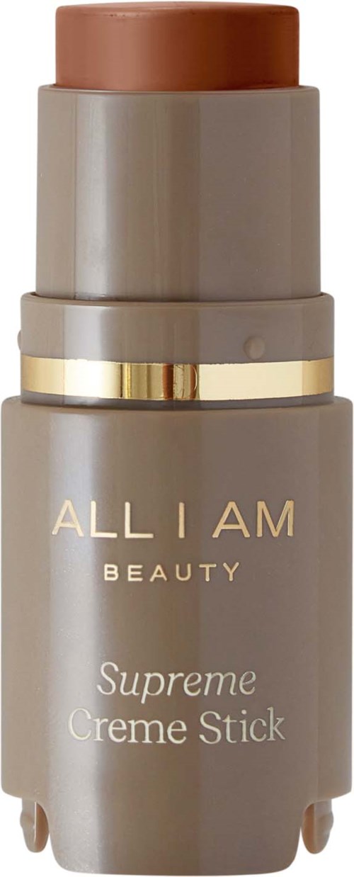 En beige flaska med gulddetaljer märkt 'ALL I AM BEAUTY' och 'Supreme Creme Stick'.
