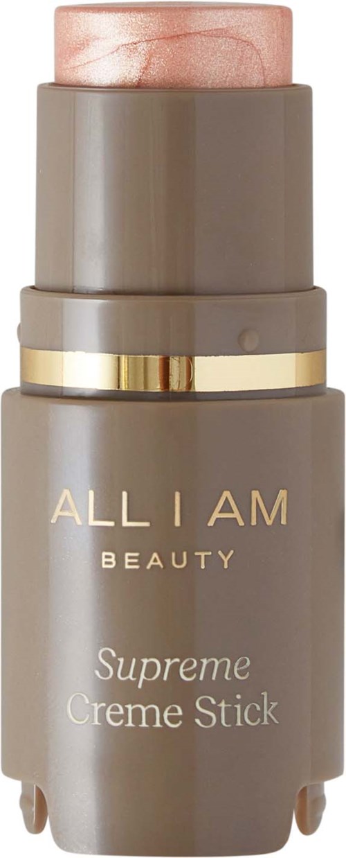 En grå och rosa sminkstift märkt "ALL I AM BEAUTY Supreme Creme Stick" med gyllene detaljer.