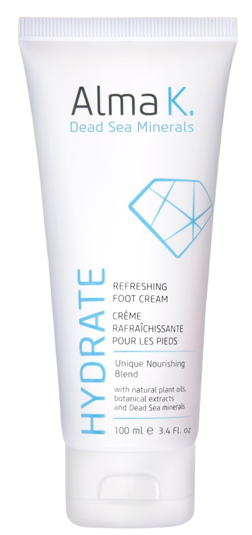 Een witte tube voetencrème met 'Alma K Dead Sea Minerals Hydrate,' blauwe geometrische tekening en tekst.