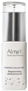 En hvid kosmetikflaske med sølv midt på, mærket 'Alma K Dead Sea Minerals,' til diamantserum.