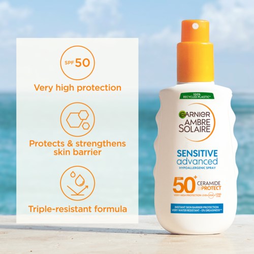Eine Sonnenschutzsprühflasche am Strand mit SPF 50, hoher Schutzwirkung, fördert die Hautbarriere, bei sonnigem Wetter.