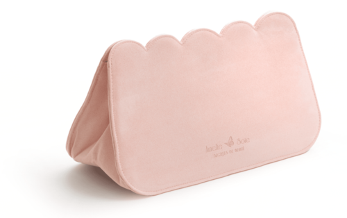 En mjuk rosa tygorganisatör med scalloped överkant, står upprätt mot en vit bakgrund.
