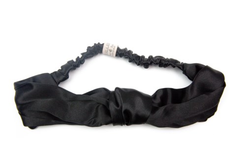 A black fabric headband with a knot in the front and an elastic back for stretch.