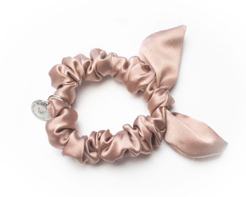 Ein pinker Satin-Haarband mit Schleife und Anhänger.