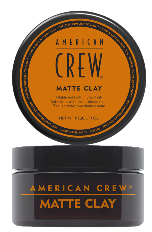 Een ronde metalen container met een zwart en oranje label voor American Crew Matte Clay haarschimmelmateriaal.