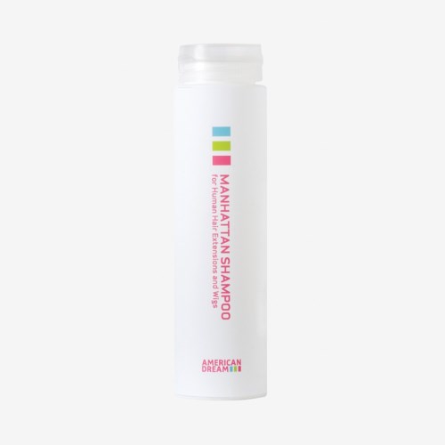 En hvit flaske med fargede linjer og rosa tekst, merket Manhattan Shampoo for menneskehårforlengelser og parykker.