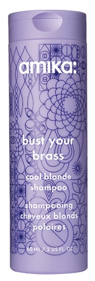 En lång, lila schampoflaska med blommönster och vit text som marknadsför en produkt för blont hår.