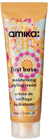 En tub med Amika First Base återfuktande stylingskräm med färgglada cirkulära och geometriska mönster på förpackningen.