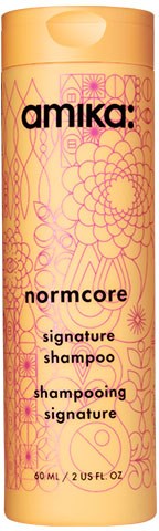 Amika: Normcore signature shampoo bottle with yellow and pink floral designs. Text includes product name and details.