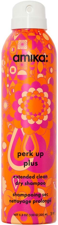 Ljusrosa och orange flaska med blommiga och geometriska mönster, märkning 'amika: perk up plus'. Det är en torrschampoflaska.