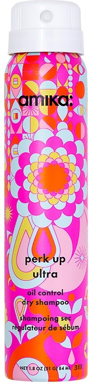 En lång schampoflaska med färgglad blom- och geometrisk design, märkt 'amika perk up ultra.'