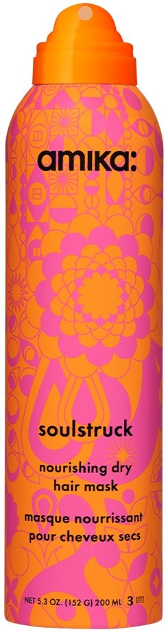 En lång rosa flaska med orange lock, dekorerad med blommor och blad, märkt som närande torrhårsmask.