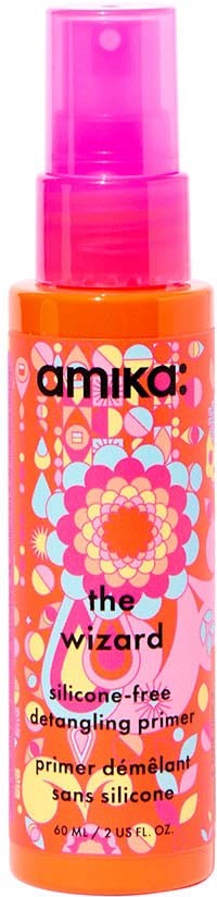 En klar orange flaske med en pink spray beholder har farverige blomster- og geometriske designs. Den er mærket "amika" og beskriver en silikonfri frizz begænsende primer.