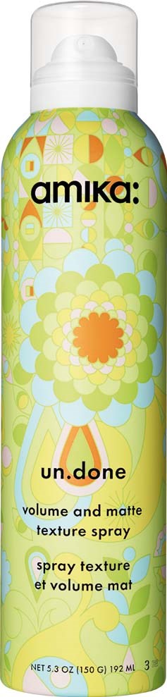Flaskans design med blommor i gult och grönt och text i svart och orange för volym och mattspray.