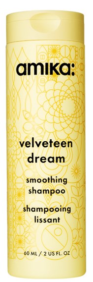 Yellow bottle of Amika Velveteen Dream smoothing shampoo with decorative patterns and black text.